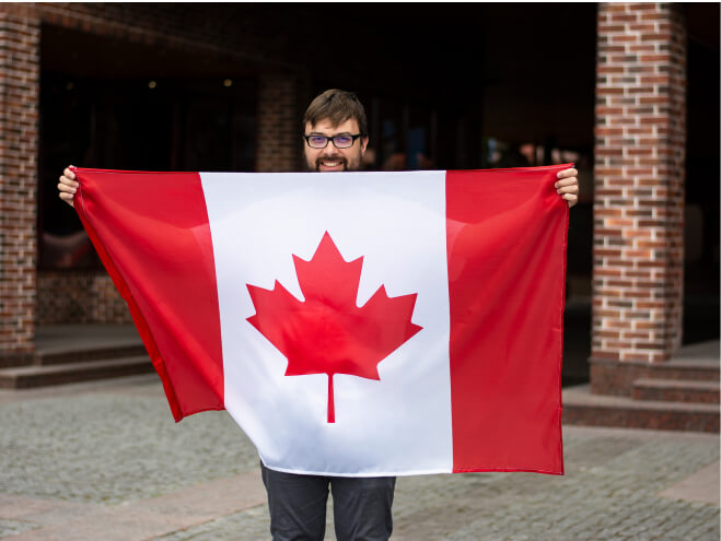 A photo of a man in glasses holding Canadian flag